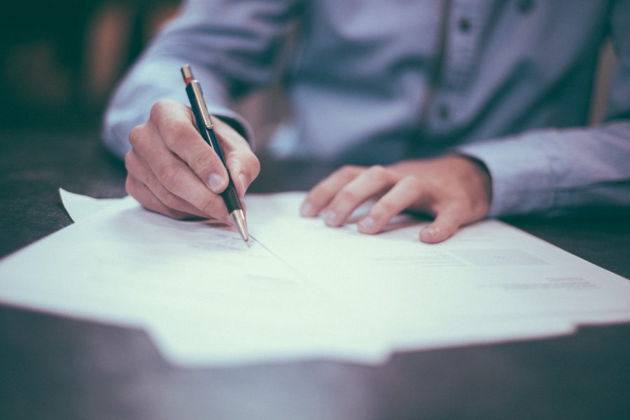 up close of man writing on a piece of paper