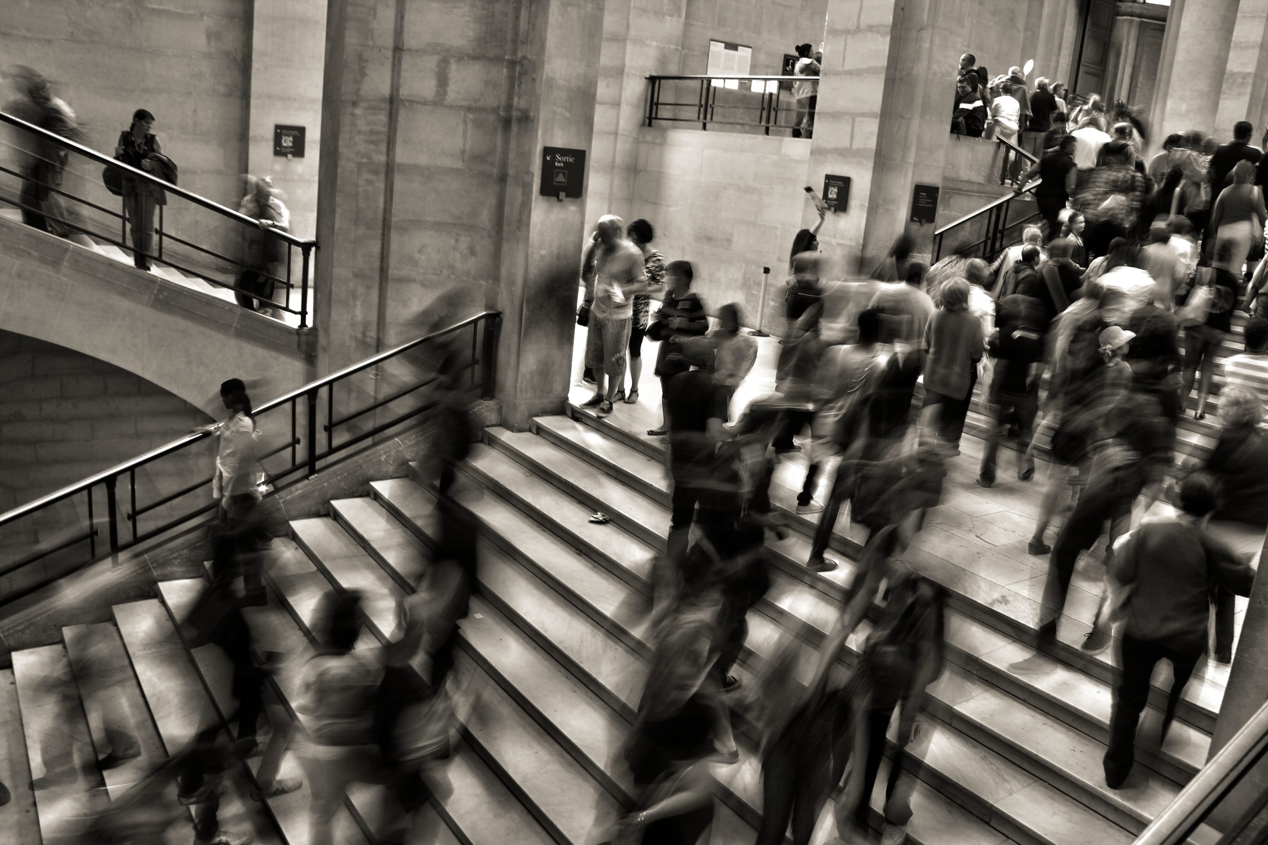 black and white image of people walking in halls