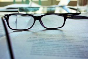 pair of glasses sitting on pages